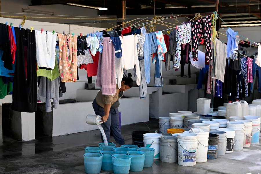 Imagen del 11 de diciembre de 2024 de una migrante vertiendo agua en una cubeta en un albergue, en la ciudad fronteriza de Reynosa, Tamaulipas, México. (Xinhua/Li Muzi)