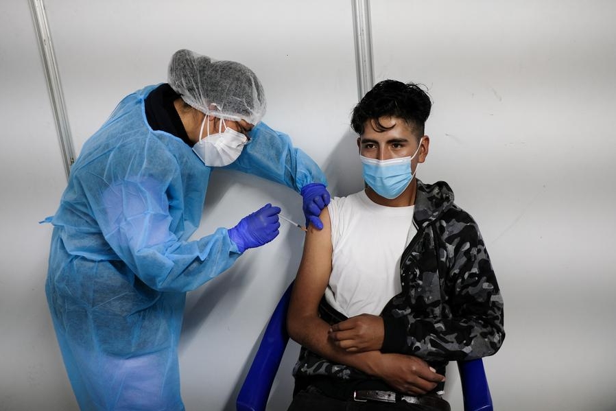 Imagen de archivo de una trabajadora de salud aplicando la tercera dosis de una vacuna contra la enfermedad del nuevo coronavirus (COVID-19), a un hombre, en el Campo Ferial "Chuquiago Marka", en La Paz, Bolivia. (Xinhua/Mateo Romay)