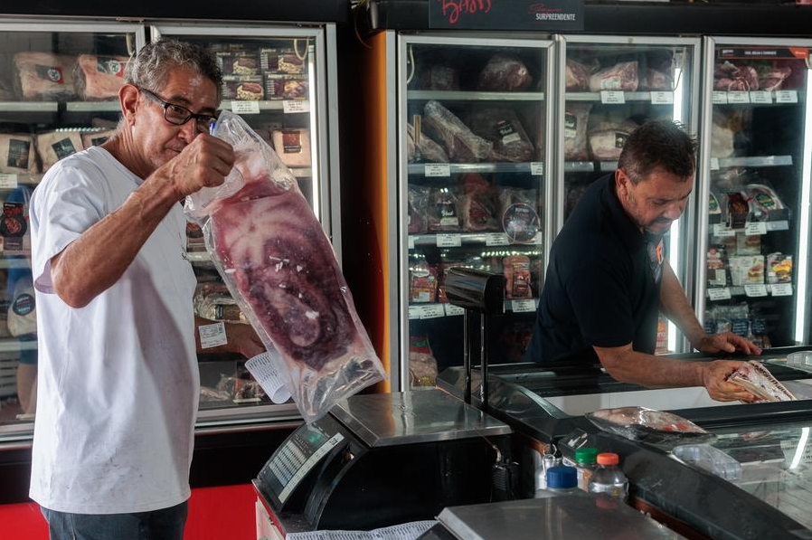 Imagen del 20 de diciembre de 2024 de un vendedor sosteniendo un trozo de carne en la tienda Frigo SeaLand en la Central de Abastecimiento de Alimentos (Ceasa), en Río de Janeiro, Brasil. (Xinhua/Claudia Martini)