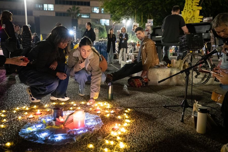 Una mujer coloca una vela en el piso en medio de reportes sobre un acuerdo de cese al fuego entre Israel y Hamas, en una plaza, en Tel Aviv, Israel, el 15 de enero de 2025. (Xinhua/Chen Junqing)