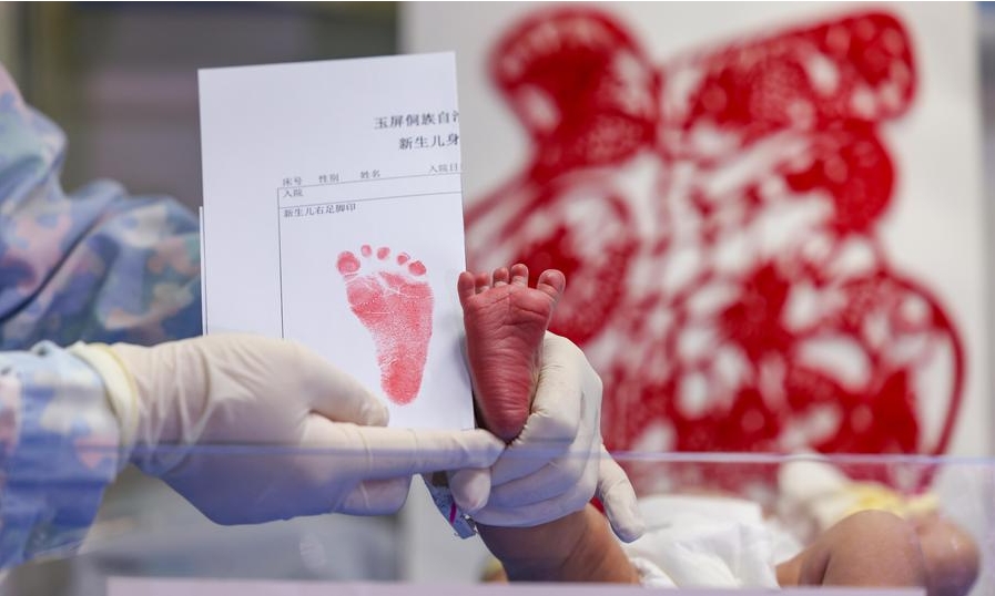 Una enfermera muestra la impresión del pie de un bebé recién nacido, cuyo signo del zodiaco chino es el dragón, en un hospital del distrito autónomo de la etnia dong de Yuping, en la ciudad de Tongren de la provincia suroccidental china de Guizhou, el 10 de febrero de 2024, primer día del Año Nuevo lunar. (Xinhua/Hu Panxue)