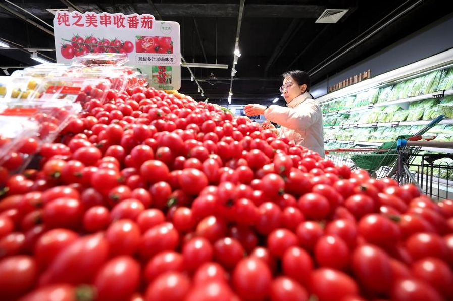 Una mujer selecciona frutas y verduras en un supermercado en Shijiazhuang, capital de la provincia septentrional china de Hebei, el 9 de enero de 2025. (Xinhua/Liang Zidong) 