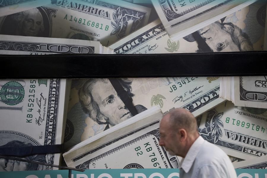 Imagen del 23 de diciembre de 2024 de un hombre caminando frente a un local de venta de divisas, en la ciudad de Buenos Aires, capital de Argentina.(Xinhua/Martín Zabala)