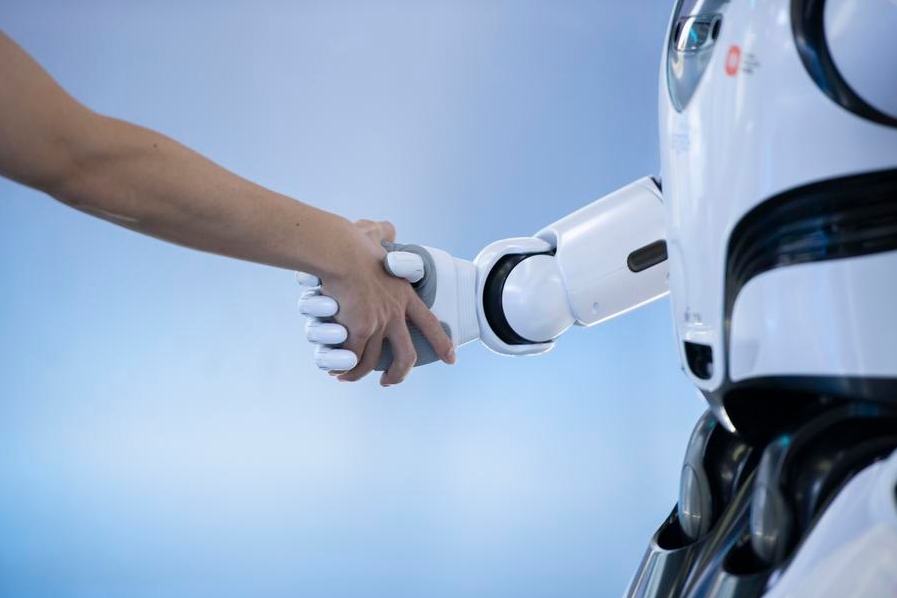 Una persona saluda de mano a un robot en una empresa de tecnología y ciencia en Shenzhen, en la provincia de Guangdong, en el sur de China, el 26 de junio de 2024. (Xinhua/Mao Siqian)