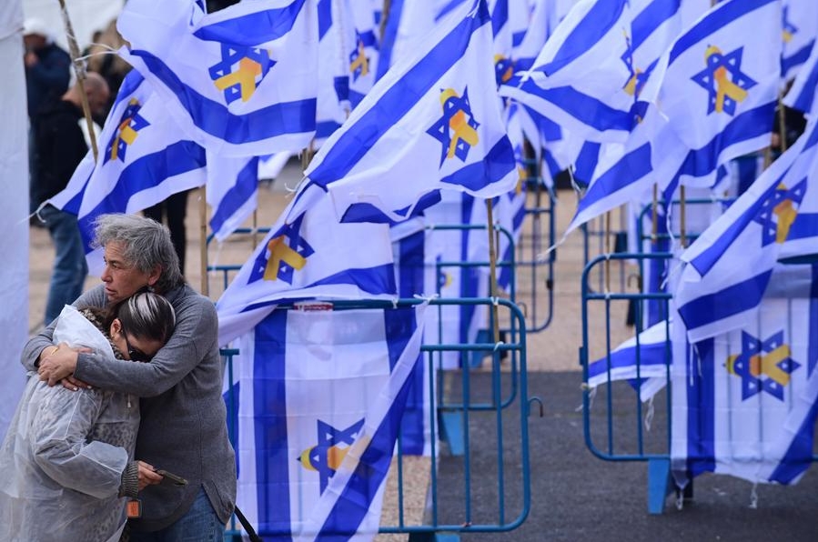 Personas observan la transmisión televisada de la entrega de los cuerpos de rehenes israelíes en una plaza, en Tel Aviv, Israel, el 20 de febrero de 2025. (Xinhua/Tomer Neuberg/JINI)