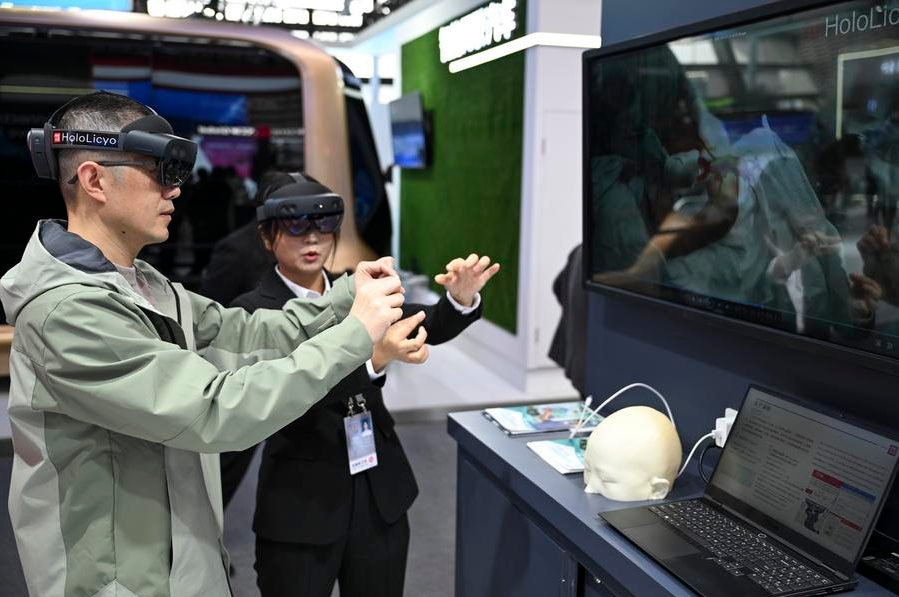 Un visitante prueba un sistema holográfico inteligente de imágenes médicas bajo la guía de una asistente en la exposición "La luz de la Internet", en Wuzhen, ciudad de la provincia oriental china de Zhejiang, el 19 de noviembre de 2024. (Xinhua/Cai Xiangxin)