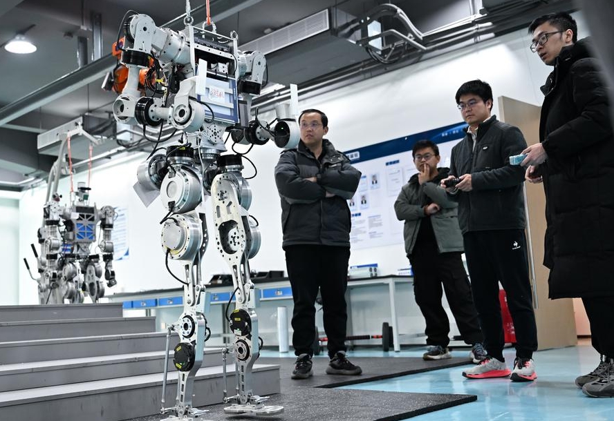 Miembros del equipo de investigación y desarrollo de Wuhan Glory Road Intelligent Technology Co., Ltd. depuran robots humanoides en la sede de la compañía, en Wuhan, capital de la provincia central china de Hubei, el 24 de febrero de 2025. (Xinhua/Du Zixuan)