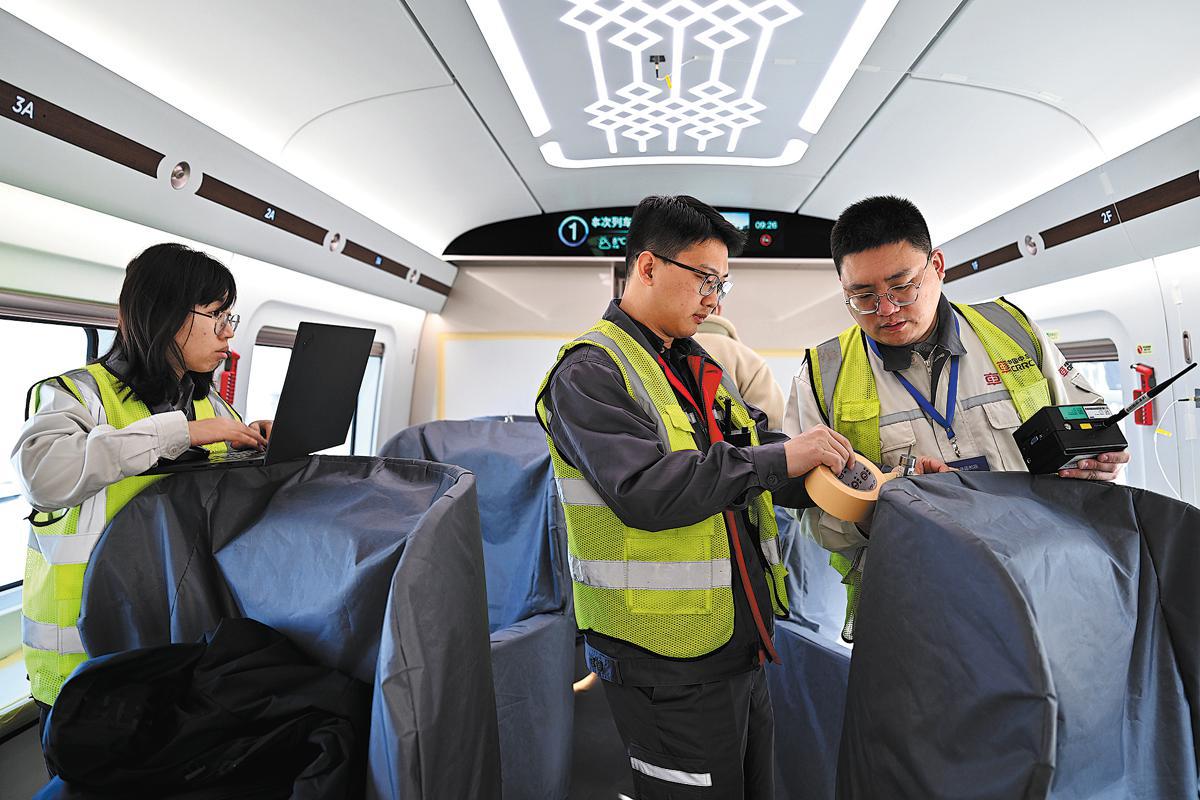 Técnicos instalan sensores de temperatura mientras examinan un vagón de un prototipo de tren de alta velocidad CR450 en el Centro Nacional de Pruebas Ferroviarias de la Academia de Ciencias Ferroviarias de China, Beijing, 25 de febrero del 2025. (Foto: Li Xin/ Xinhua)