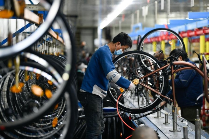 Imagen del 13 de enero de 2021 de trabajadores ensamblando piezas de bicicleta en una fábrica, en el distrito de Wuqing de Tianjin, en el norte de China. (Xinhua/Sun Fanyue) 