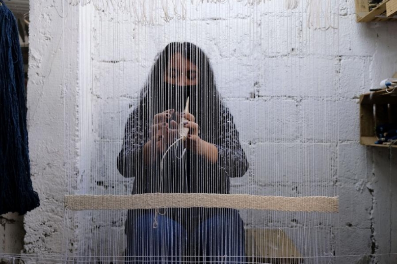 Una mujer elabora una prenda utilizando un telar manual en el taller del artista textil Ignacio Netzahualcóyotl, en Tlaxcala, México, el 11 de octubre del 2021. (Xinhua/Jesús Alvarado)