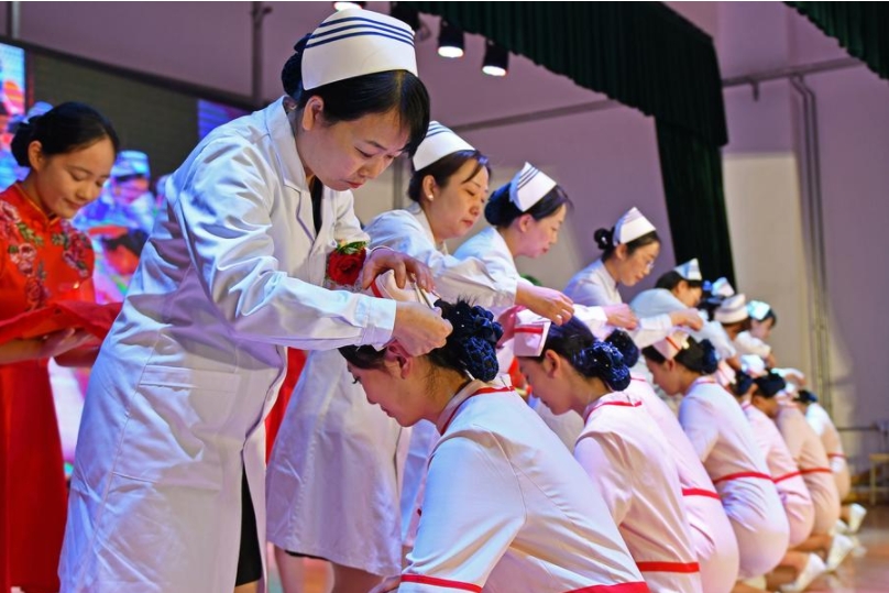 Estudiantes de enfermería reciben sus gorras de enfermeras en una ceremonia en la Escuela de Enfermería de Yantai, en la provincia oriental china de Shandong, el 8 de mayo de 2025. (Xinhua/Sun Wentan)