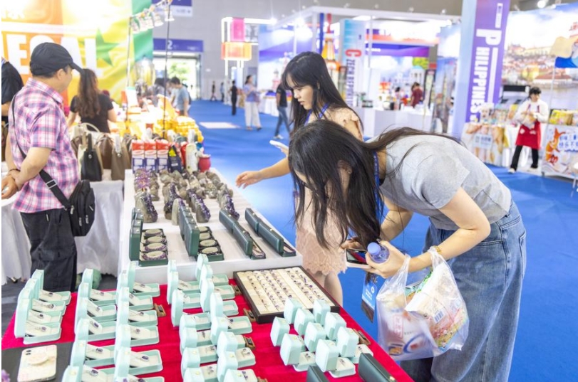 Visitantes observan productos de piedras preciosas en el pabellón nacional de Uruguay en la VII Feria Internacional de Inversión y Comercio del Oeste de China, en la municipalidad suroccidental de Chongqing, el 23 de mayo de 2025. (Xinhua/Huang Wei)