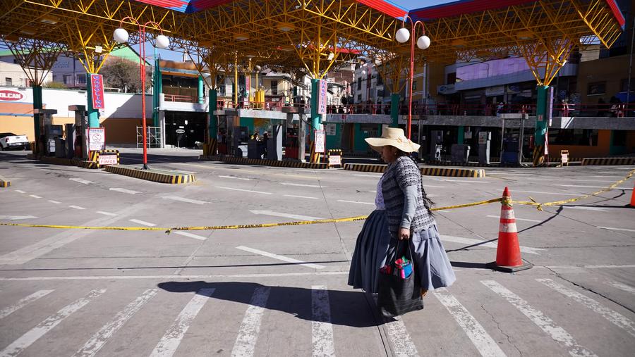 Una mujer camina frente a una estación de servicio, en La Paz, Bolivia, el 3 junio de 2025. (Xinhua/Javier Mamani) 