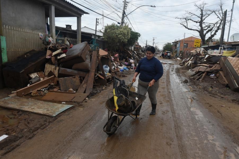 Una mujer empuja un carrito mientras camina por una calle afectada por las inundaciones provocadas por las fuertes lluvias, en la Isla Pintada, en la ciudad de Porto Alegre, capital del estado de Río Grande do Sul, Brasil, el 18 de junio de 2024. (Xinhua/Lucio Tavora)
