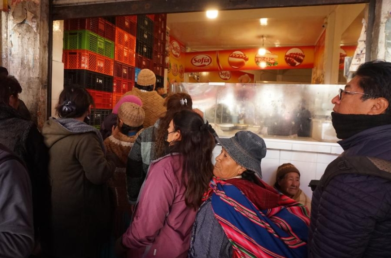Personas esperan en fila para obtener una ración de pollo, en la ciudad de La Paz, Bolivia, el 13 de junio de 2025. (Xinhua/Javier Mamani) 