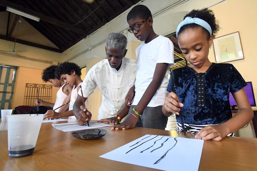 El pintor y calígrafo, Alexis González (c), imparte un curso de pintura tradicional china a un grupo de niños en la Casa de las Artes y Tradiciones China, en La Habana, capital de Cuba, el 28 de julio de 2025. (Xinhua/Joaquín Hernández)