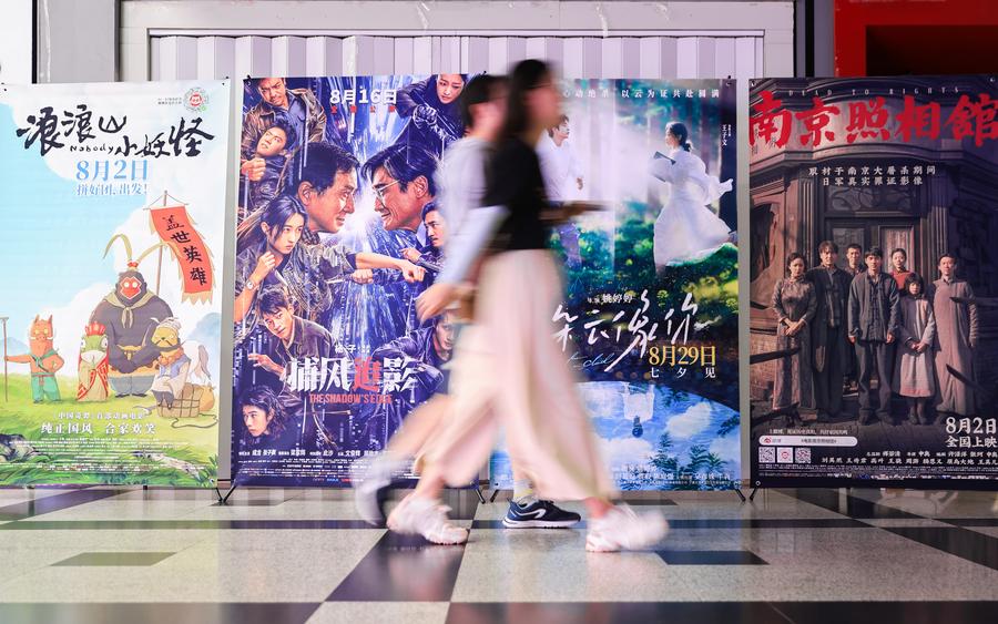 Cinéfilos pasan junto a carteles de películas en un cine en Nanjing, en la provincia oriental china de Jiangsu, el 17 de agosto de 2025. (Su Yang/Xinhua)