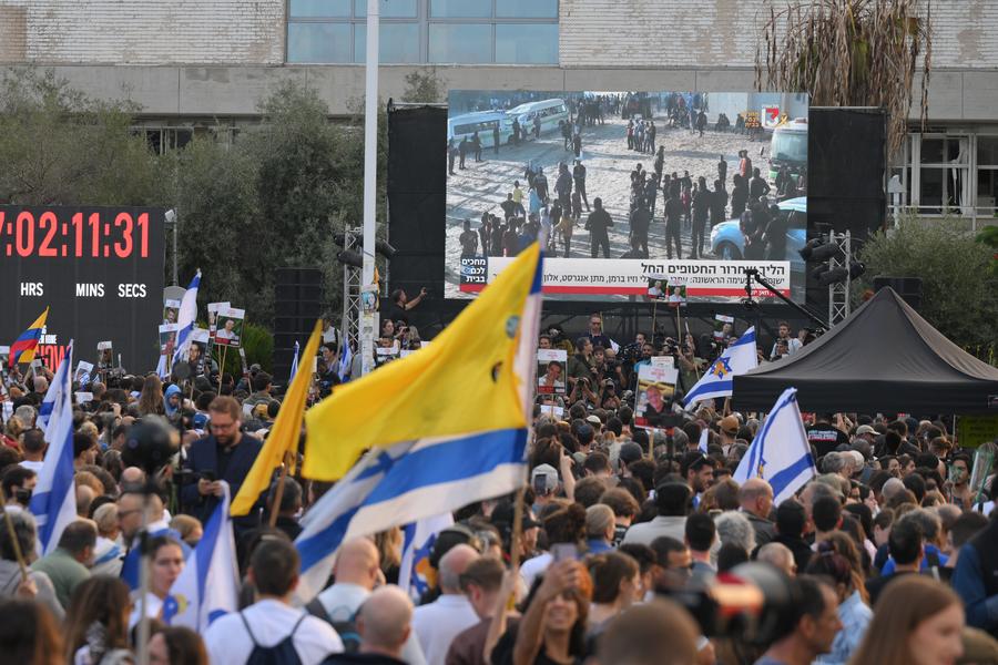 Imagen del 13 de octubre de 2025 de personas viendo la transmisión en directo de la liberación de los rehenes en una plaza de Tel Aviv, Israel.  (Xinhua/Jamal Awad)