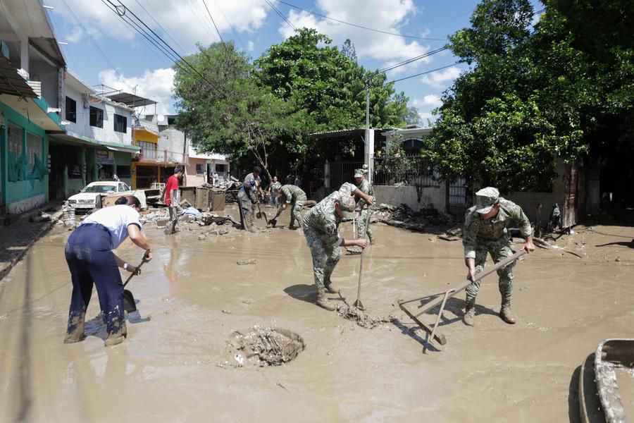 Personas intentan limpiar una calle inundada por las lluvias, en la ciudad de Poza Rica, en el estado de Veracruz, México, el 12 de octubre de 2025. El estado mexicano de Veracruz, en la región oriental del país, enfrenta una severa emergencia derivada del desbordamiento del río Cazones que arrasó con viviendas, caminos y cosechas, en la región norte de la localidad del Golfo de México. (Xinhua/Francisco Cañedo)