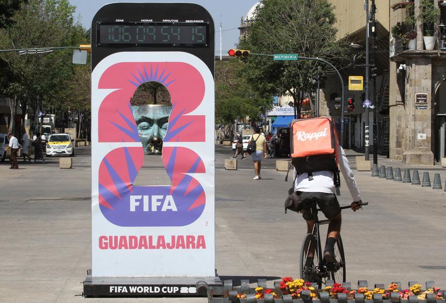 Un repartidor de comida circula en una bicicleta junto a un anuncio de la Copa Mundial de Fútbol FIFA 2026, en la ciudad de Guadalajara, capital del estado de Jalisco, México, el 24 de febrero de 2026. (Xinhua/Str)