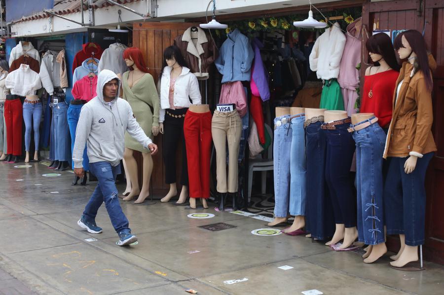 Un hombre camina frente a una tienda de ropa, en el distrito de Chorrillos, en el sur de Lima, Perú, el 27 de mayo de 2025. (Xinhua/Mariana Bazo) 