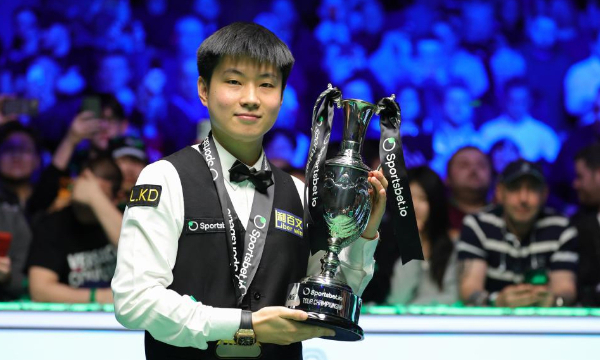 El atleta chino Zhao Xintong posa con su trofeo durante la ceremonia de premiación después de la final contra el inglés Judd Trump en el Campeonato Gira de Snooker 2026 en Manchester, Gran Bretaña, 5 de abril del 2026. (Foto: Zhai Zheng /Xinhua)