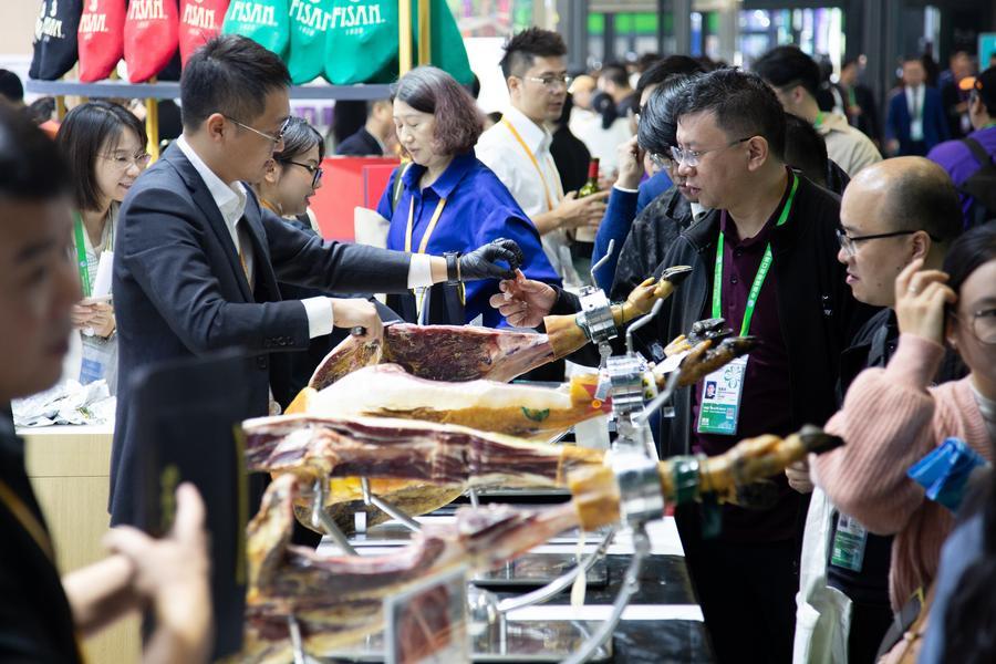 Visitantes hacen fila para probar jamón ibérico de España en el área de exhibición de productos alimenticios y agrícolas durante la VIII Exposición Internacional de Importaciones de China (CIIE, por sus siglas en inglés) en Shanghai, en el este de China, el 7 de noviembre de 2025. (Xinhua/Tian Weiwei)