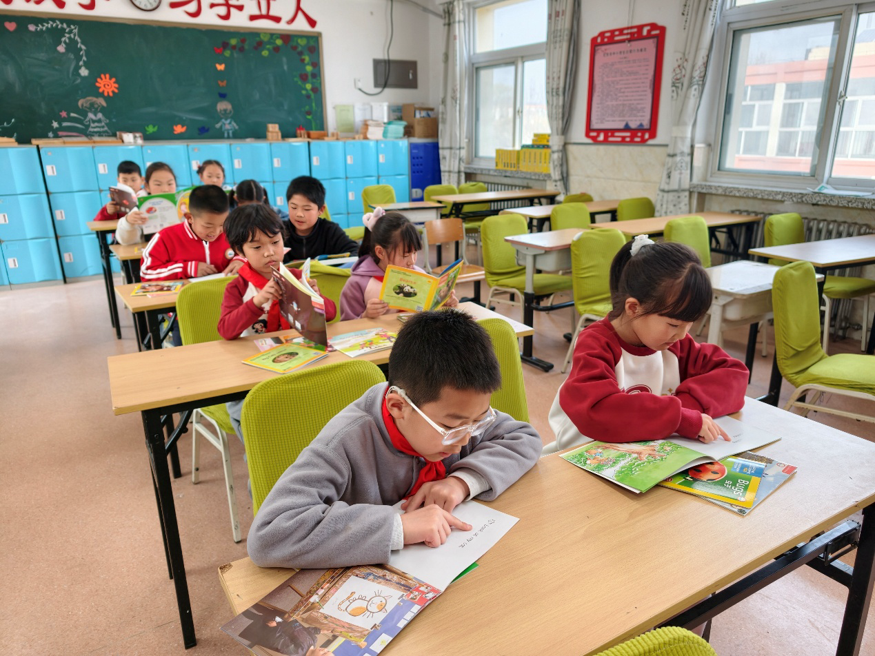 Niños leyendo libros ilustrados en inglés en la Escuela Primaria de Dongshaoqu, distrito de Miyun, Beijing. Foto: Diario del Pueblo digital/Chang Sha