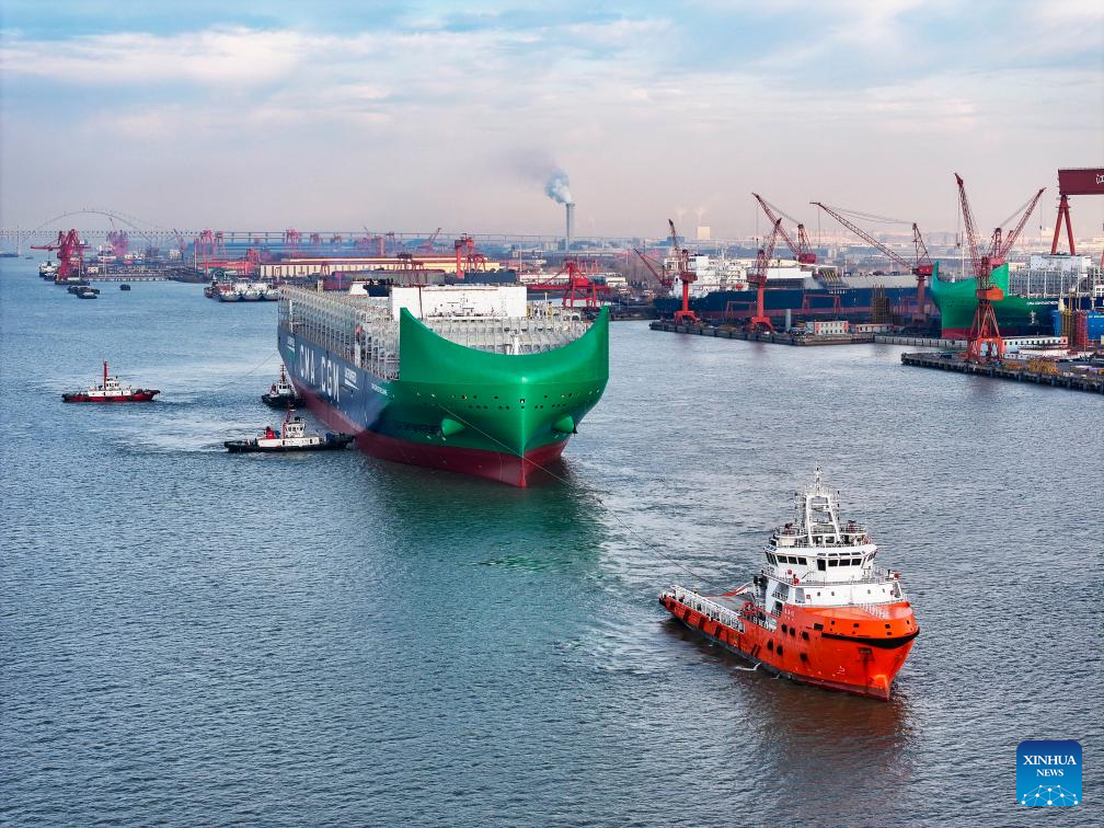 Imagen tomada con un dron el 27 de diciembre de 2025 de un buque de contenedores ultragrande, desarrollado y construido independientemente por Yangzijiang Shipbuilding Group, jalado por remolcadores a lo largo del río Yangtse, en Taizhou, en la provincia de Jiangsu, en el este de China. 