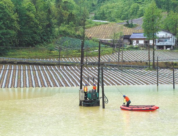 Trabajadores de la Corporación Estatal de Redes de China reparan instalaciones eléctricas dañadas en el condado de Hefeng, prefectura autónoma de Enshi Tujia y Miao, provincia de Hubei, después de días de fuertes lluvias que provocaron inundaciones y deslizamientos de tierra, 19 de mayo del 2026. (Foto: Yang Shunpi/ China Daily)
