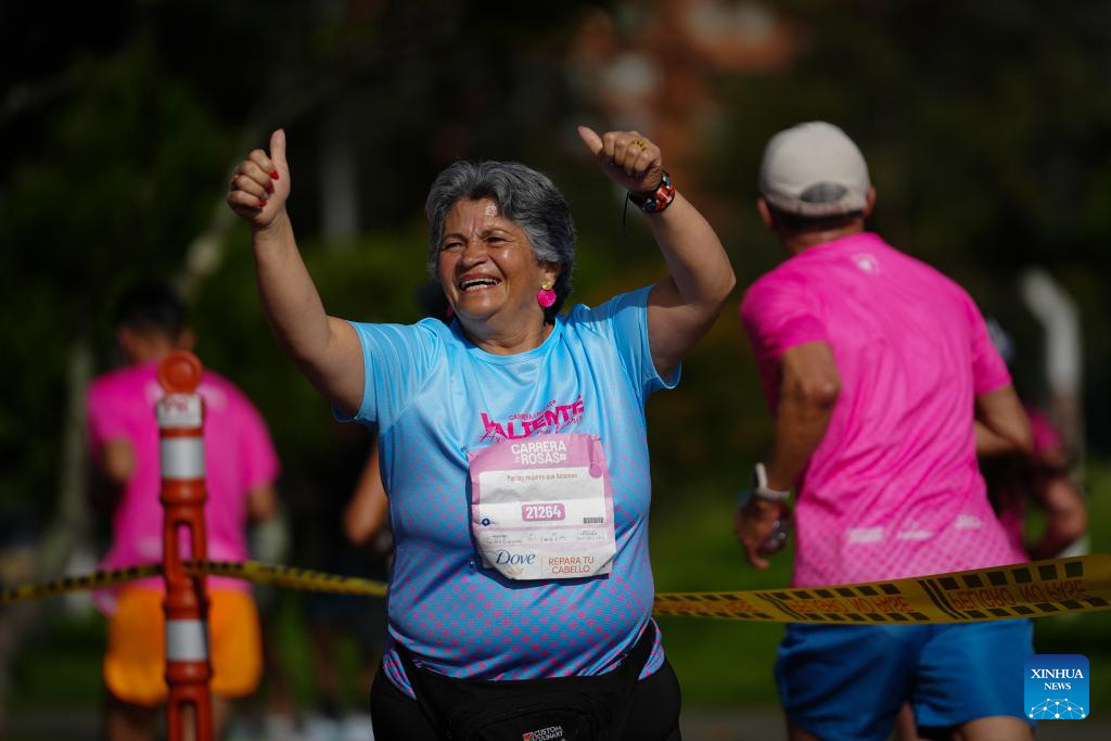 Una mujer reacciona mientras participa en la Carrera de las Rosas, en Bogotá, Colombia, el 24 de mayo de 2026. Miles de colombianos se sumaron el domingo a la tercera edición de la Carrera de las Rosas, que se realizó en la ciudad de Bogotá, capital del país sudamericano, para generar conciencia entre las mujeres sobre el cuidado y la prevención contra el cáncer de mama. (Xinhua/Andrés Moreno)