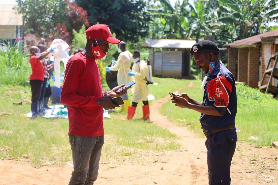 Imagen del 24 de mayo de 2026 de un voluntario publicitando información sobre la prevención del ébola a un policía, en Mongbwalu, en la provincia de Ituri, República Democrática del Congo (RDC). (Xinhua)