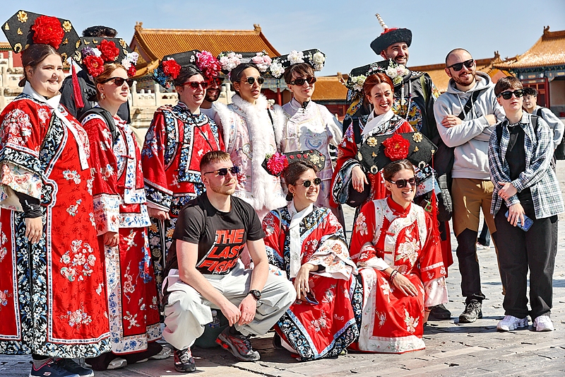 Turistas extranjeros vestidos con ropa tradicional china se hacen fotos en el Museo del Palacio Imperial en Beijing, 1º de abril del 2026. (Foto: VCG)