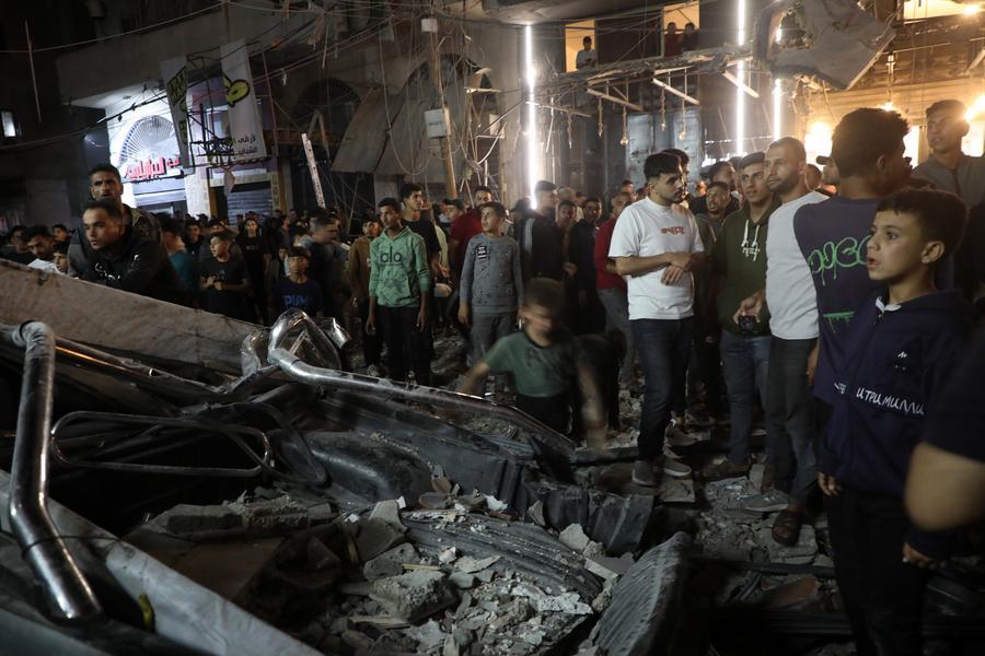 Imagen del 26 de mayo de 2026 de palestinos inspeccionando las secuelas de un bombardeo israelí que tenía como objetivo un edificio residencial, en el centro de la Ciudad de Gaza. (Xinhua/Rizek Abdeljawad) 