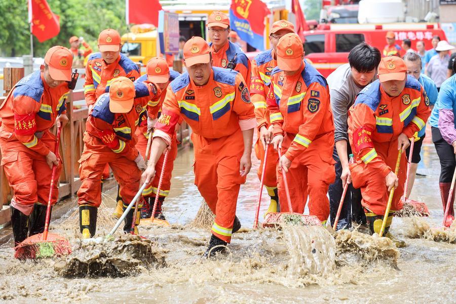 Imagen del 11 de julio de 2026 de bomberos de Kunming, de la provincia de Yunnan, en el suroeste de China, limpian el lodo y carreteras inundadas, en Guigang, en la región autónoma zhuang de Guangxi, en el sur de China. (Xinhua/Liu Jianfei) 