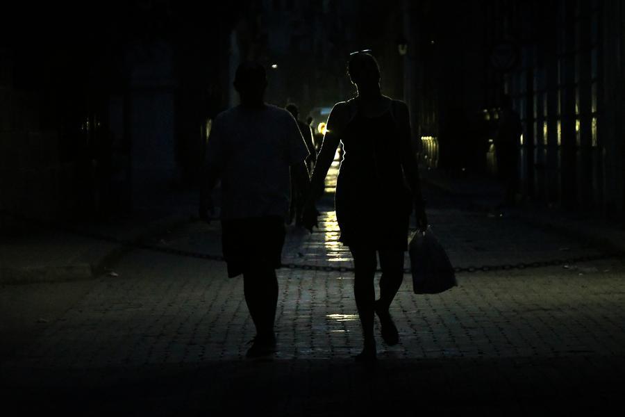 Imagen del 14 de julio de 2026 de personas caminando por una calle durante una desconexión del Sistema Electroenergético Nacional (SEN), en La Habana, capital de Cuba. (Xinhua/Joaquín Hernández) 