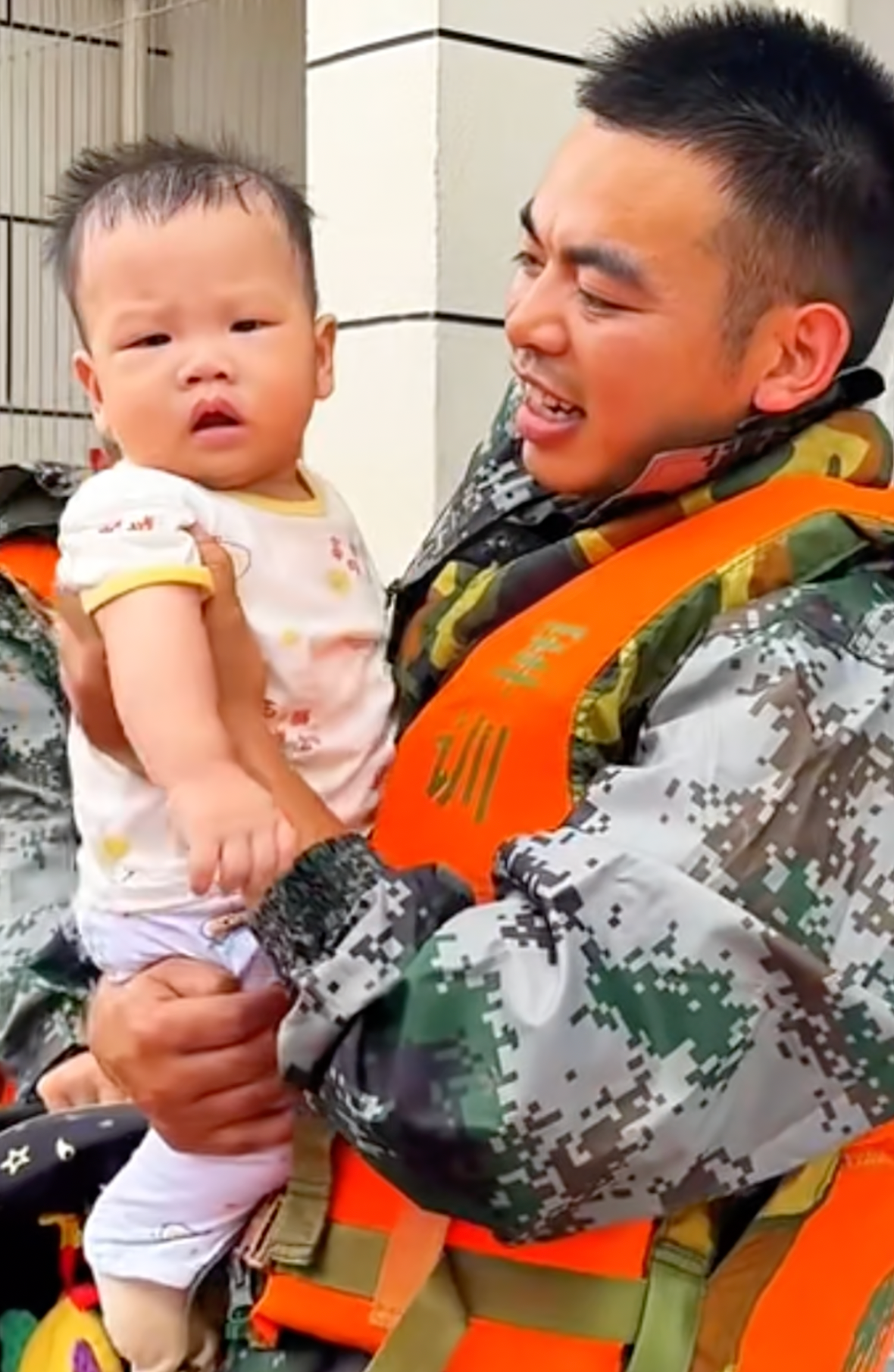 Wu Jie protege a un bebé durante las operaciones de rescate por inundación en Guigang, en la Región Autónoma Zhuang de Guangxi. [Foto: proporcionada]