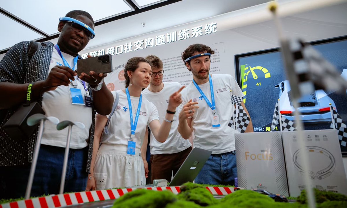 Jóvenes que asisten al cuarto Diálogo Global de la Juventud de Tsinghua experimentan el sistema de interfaz cerebro-computadora en la Ciudad de la Inteligencia Artificial de China en Hangzhou, provincia de Zhejiang, junio del 2026. (Foto: cortesía)