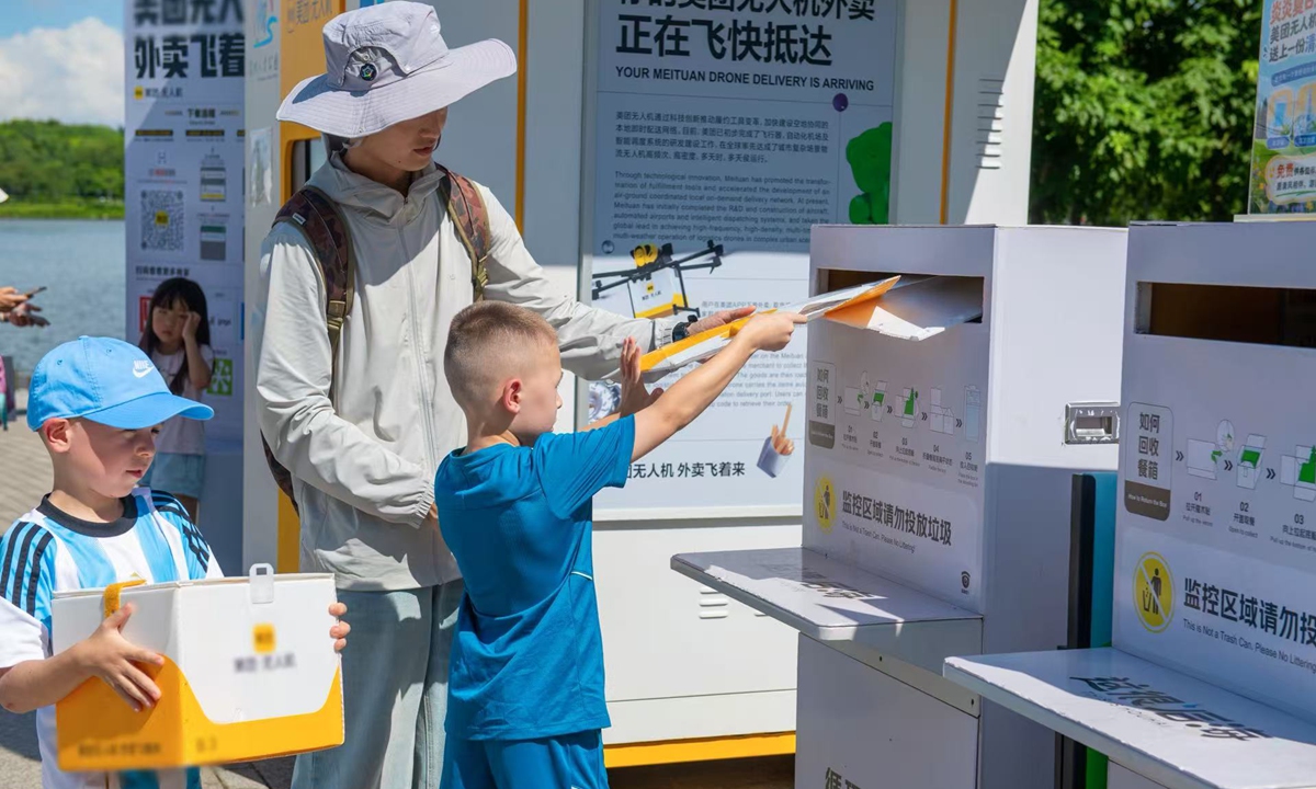 Turistas extranjeros experimentan servicios de entrega con drones en Shenzhen, provincia de Guangdong, 21 de junio de 2026. (Foto: VCG)