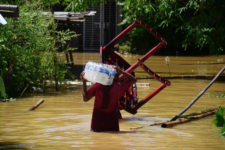 Un aldeano camina a través de las aguas de la inundación tras las fuertes lluvias, en el distrito de Jorhat del estado de Assam, en el noreste de India, el 21 de julio de 2026. (Xinhua/Str) 