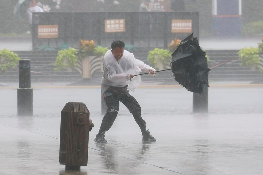 Un hombre sujeta con fuerza un paraguas que el viento ha abierto de golpe en medio de la lluvia en el distrito de Huangpu de Shanghai, en el este de China, el 9 de agosto de 2026. (Xinhua/Wang Xiang)