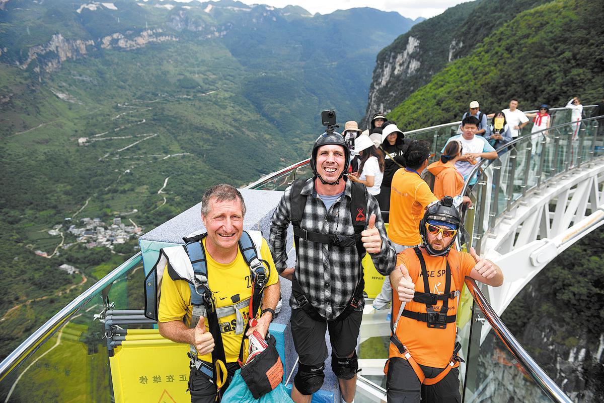 Turistas extranjeros posan para una foto antes de saltar desde una plataforma en el Gran Cañón de Nizhuhe en Xuanwei, provincia de Yunnan, 10 de agosto de 2026. [Foto: Servicios de Noticias de China]