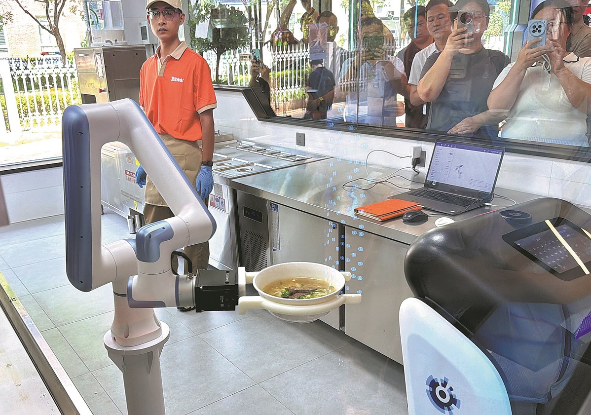 Un robot sirve fideos preparados en el primer restaurante de fideos robotizado totalmente comercial de Beijing, ubicado en el distrito de Fengtai, el 5 de agosto. LIU PING/PARA CHINA DAILY