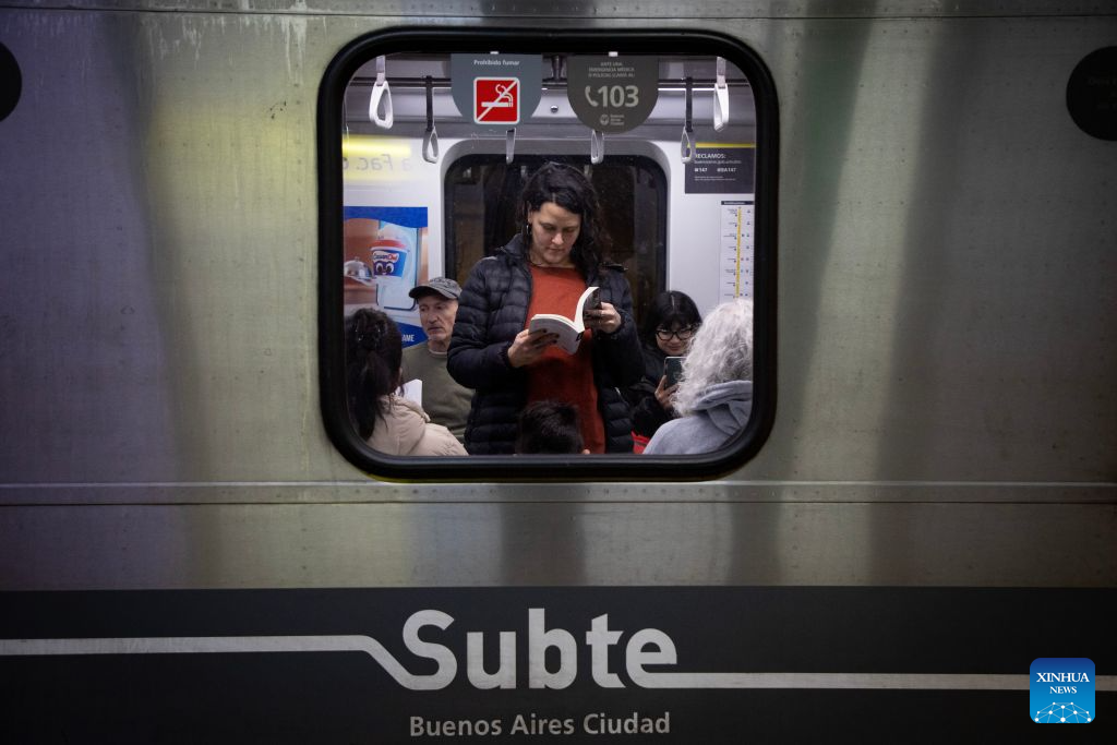Una mujer lee un libro a bordo de un vagón de la Línea H del metro en el marco del Día del Lector en conmemoración del 127 aniversario del nacimiento del escritor Jorge Luis Borges, en la ciudad de Buenos Aires, capital de Argentina, el 22 de agosto de 2026. (Xinhua/Martín Zabala)