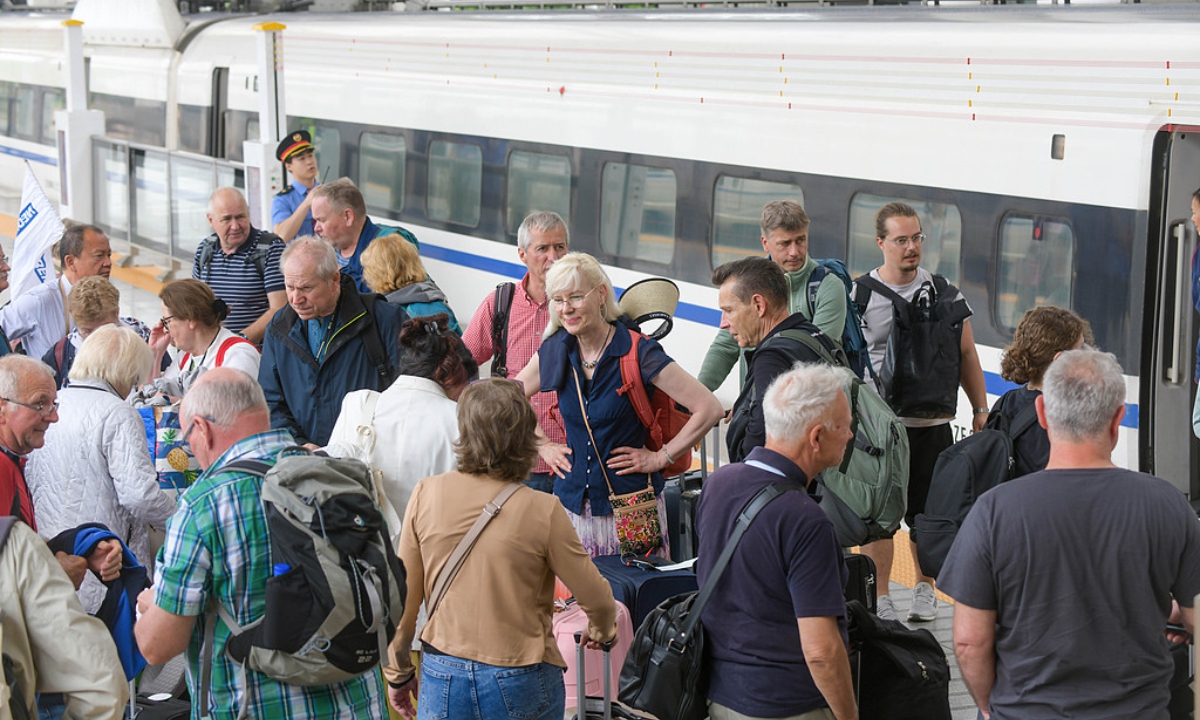Turistas extranjeros esperan para abordar un tren de alta velocidad en la estación ferroviaria de Luoyang Longmen, en Luoyang (provincia de Henan, centro de China), el 1 de mayo de 2026.