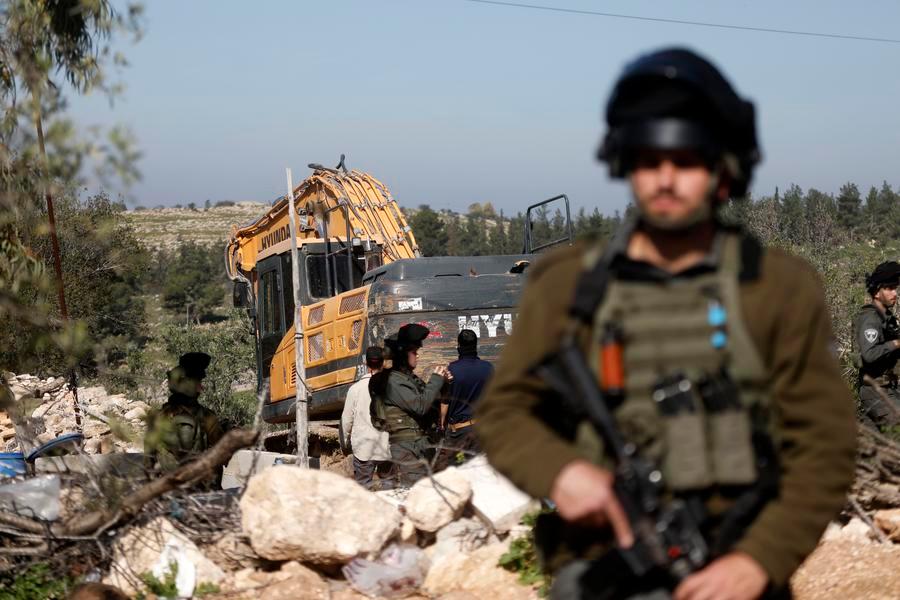 Imagen del 5 de febrero de 2026 de soldados israelíes vistos mientras una excavadora militar israelí demuele una vivienda palestina, en el poblado de Beit Awa, en el oeste de Hebrón, en Cisjordania. (Xinhua/Mamoun Wazwaz)