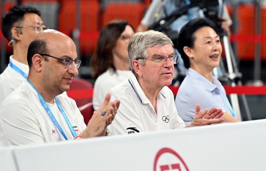 El presidente honorario vitalicio del Comité Olímpico Internacional, Thomas Bach (c), disfruta del partido del grupo A de baloncesto 3x3 femenino entre China y Qatar en los VI Juegos Asiáticos de Playa, en Sanya, en la provincia de Hainan, en el sur de China, el 25 de abril de 2026. (Xinhua/Guo Cheng) 