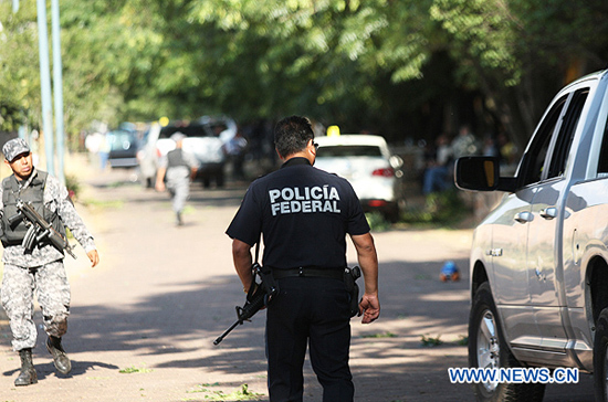 Un policía federal y militares mexicanos vigilan la escena de una balacera entre dos grupos civiles armados en la ciudad de Arandas, estado de Jalisco, al noroeste de México, el 24 de marzo de 2011. Dos grupos de hombres armados se enfrentaron durante aproximadamente 15 minutos, dejando como saldo varias personas lesionadas y dos muertos.