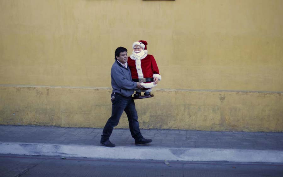Un hombre camina por la calle con una figura de Papá Noel en el centro de la Ciudad de Guatemala, el 6 de diciembre de 2012. Foto del 6 de diciembre de 2012. [Foto/agencias]