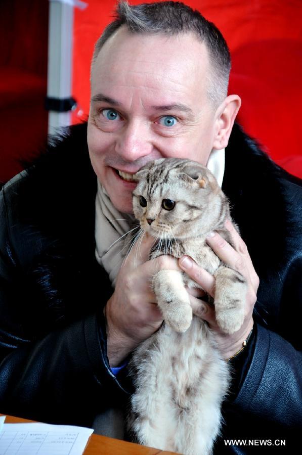 Un hombre muestra su gato en el Salón Internacional del Gato en Bishkek, Kirguistán, el 16 de febrero de 2013. El sábado comenzó la exposición de dos días duración organizada por la Federación Mundial del Gato, donde participarán más de 80 especies del famoso felino. (Romano/Xinhua)